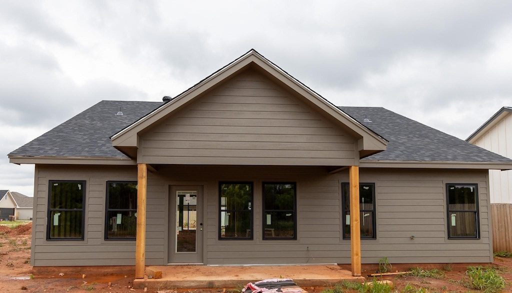 back of property with a shingled roof