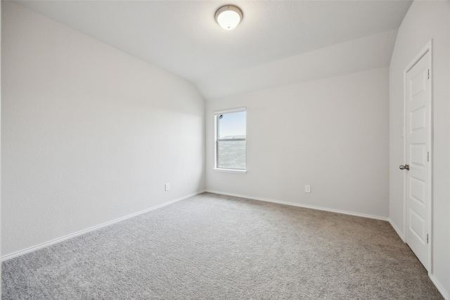 unfurnished bedroom with lofted ceiling, carpet, and baseboards