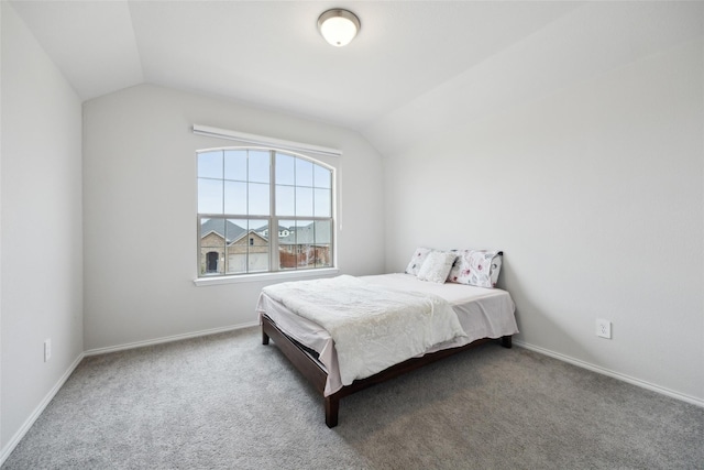 bedroom featuring lofted ceiling, carpet floors, and baseboards