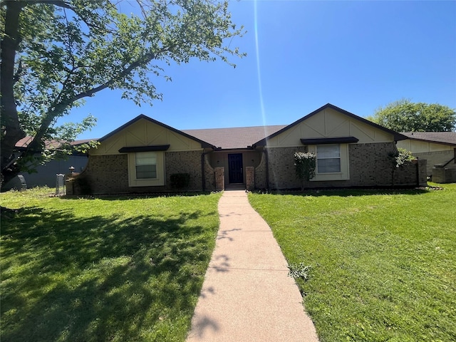 ranch-style home featuring a front yard and brick siding