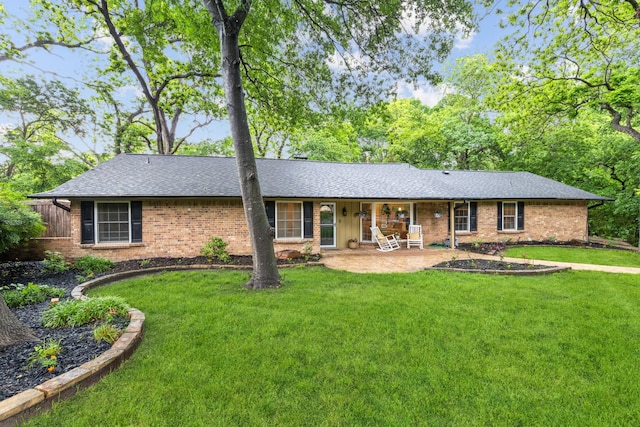 single story home featuring a front yard, roof with shingles, and brick siding
