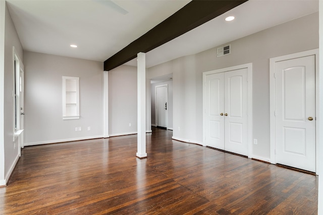 interior space with baseboards, beam ceiling, visible vents, and wood finished floors