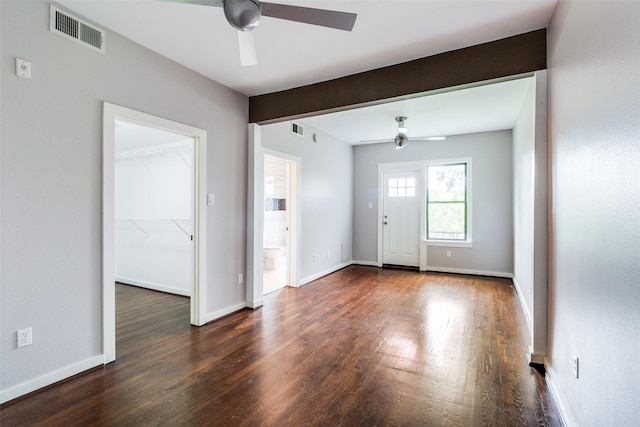 interior space with ceiling fan, visible vents, and dark wood finished floors
