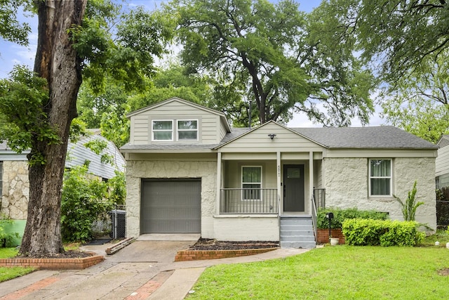 view of front facade with a porch, roof with shingles, an attached garage, driveway, and a front lawn