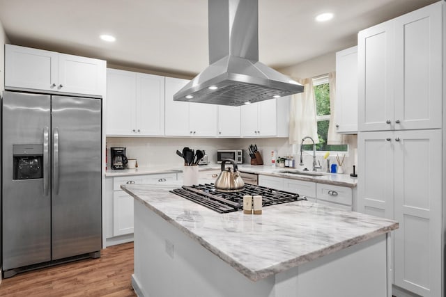 kitchen featuring white cabinetry, appliances with stainless steel finishes, a sink, and island exhaust hood