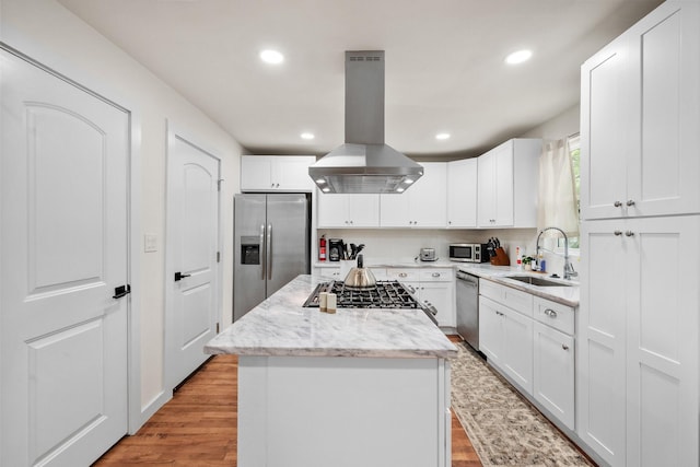 kitchen featuring recessed lighting, a center island, a sink, island exhaust hood, and appliances with stainless steel finishes