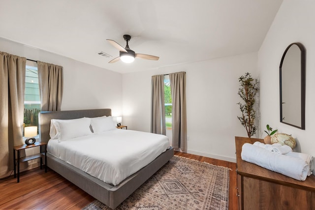 bedroom with multiple windows, visible vents, wood finished floors, and a ceiling fan