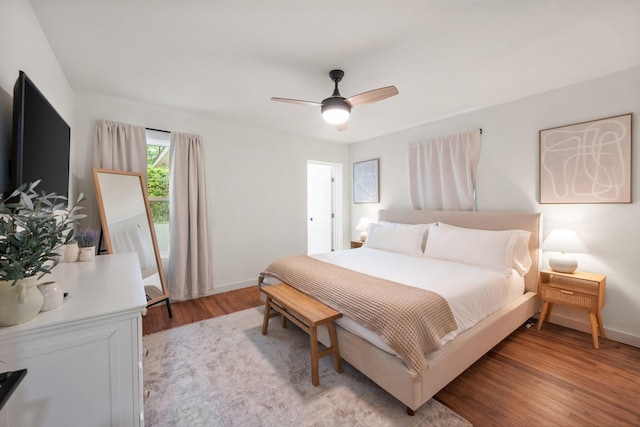 bedroom with light wood finished floors, baseboards, and ceiling fan
