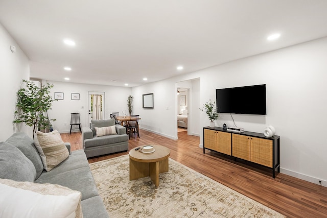 living room with wood finished floors, baseboards, and recessed lighting