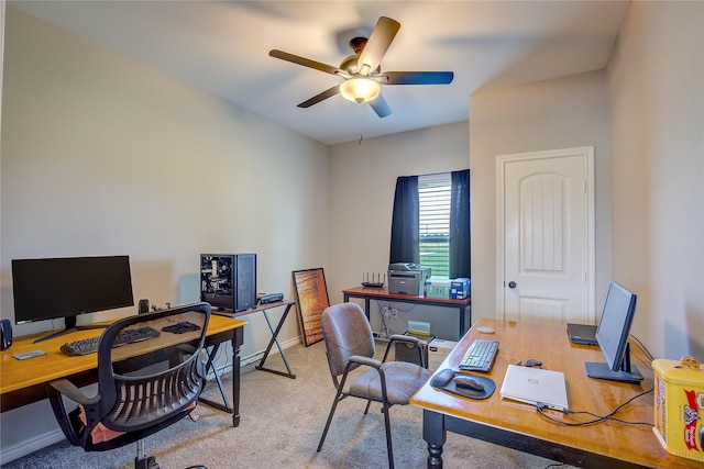 carpeted office with baseboards and a ceiling fan