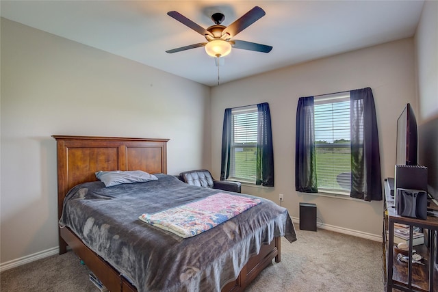 bedroom with baseboards, a ceiling fan, and light colored carpet
