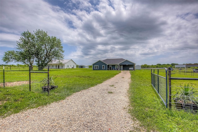 view of front of home featuring an attached garage, fence, a front yard, and driveway