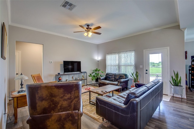 living area with a ceiling fan, crown molding, visible vents, and wood finished floors