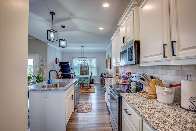 kitchen with a sink, crown molding, wood finished floors, stainless steel appliances, and tasteful backsplash