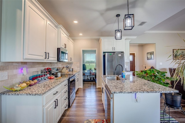 kitchen featuring a sink, a breakfast bar, visible vents, an island with sink, and appliances with stainless steel finishes