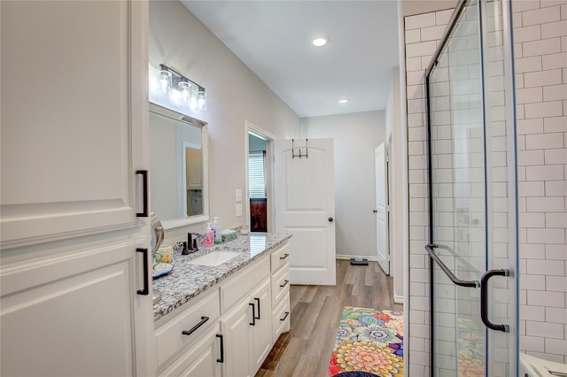 full bathroom with a shower stall, vanity, recessed lighting, and wood finished floors
