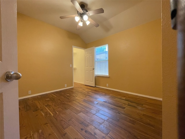 spare room featuring ceiling fan, vaulted ceiling, baseboards, and wood-type flooring