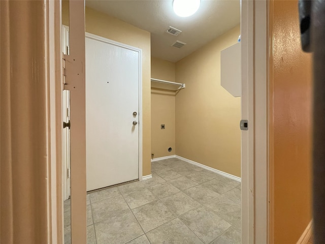 clothes washing area featuring light tile patterned floors, laundry area, hookup for an electric dryer, visible vents, and baseboards