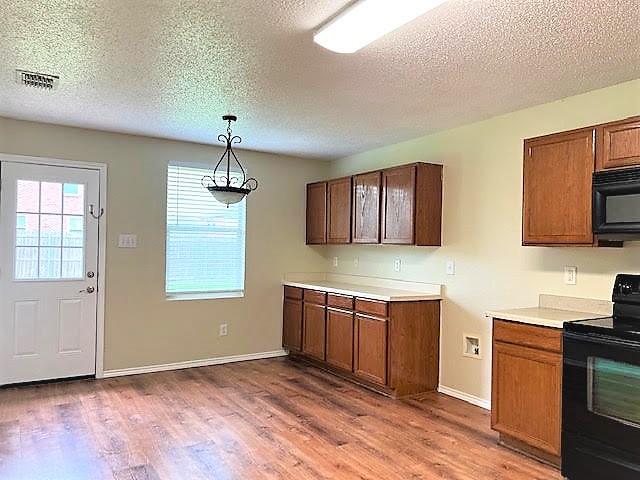 714 Kinston Ct, Wylie, TX 75098 - kitchen with black appliances, light countertops, visible vents, and wood finished floors
