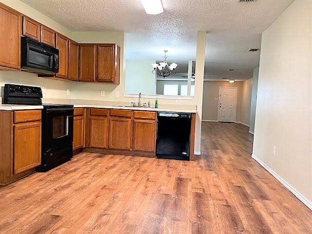 714 Kinston Ct, Wylie, TX 75098 - kitchen with a sink, brown cabinetry, and black appliances
