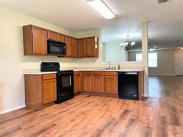714 Kinston Ct, Wylie, TX 75098 - kitchen featuring brown cabinetry, black appliances, and light countertops