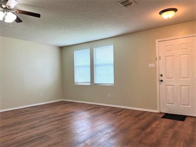 714 Kinston Ct, Wylie, TX 75098 - unfurnished room featuring a textured ceiling, dark wood-style floors, and visible vents