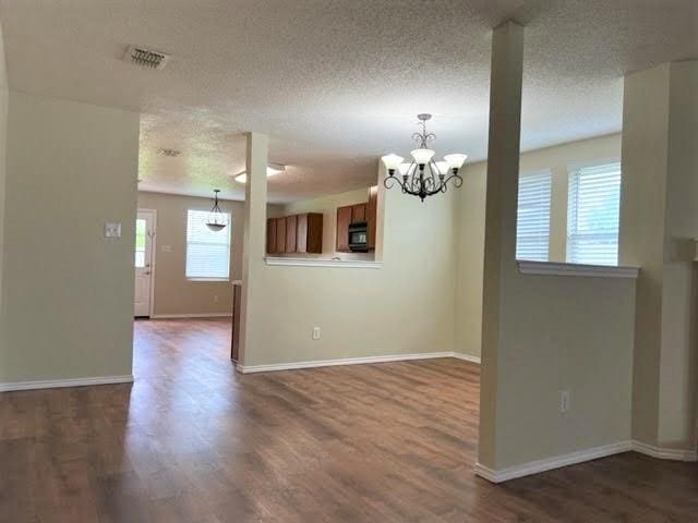 714 Kinston Ct, Wylie, TX 75098 - interior space featuring a textured ceiling, a notable chandelier, baseboards, and dark wood finished floors