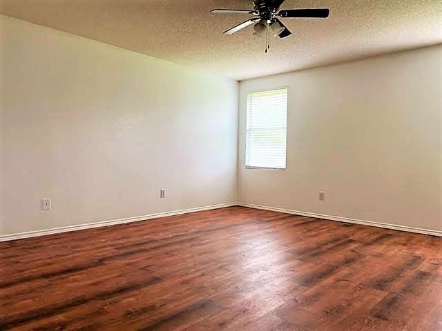 714 Kinston Ct, Wylie, TX 75098 - spare room featuring a textured ceiling, baseboards, ceiling fan, and dark wood-style floors