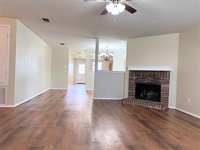 714 Kinston Ct, Wylie, TX 75098 - unfurnished living room featuring baseboards, wood finished floors, and ceiling fan with notable chandelier