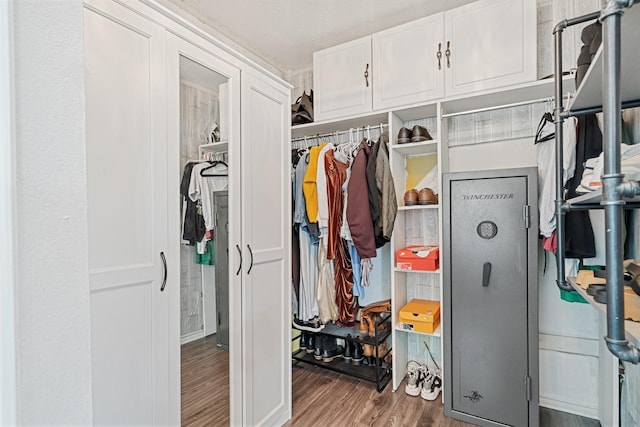 walk in closet with wood finished floors