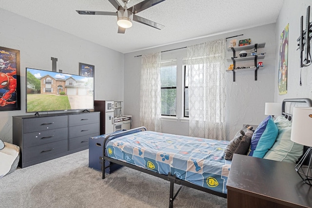 carpeted bedroom with a ceiling fan and a textured ceiling