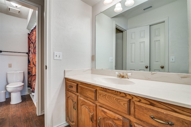 2605 Nighthawk Dr, Plano, TX 75025 - full bathroom with toilet, vanity, visible vents, and wood finished floors