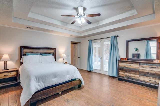 2605 Nighthawk Dr, Plano, TX 75025 - bedroom with wood finished floors, a textured ceiling, visible vents, a raised ceiling, and access to outside