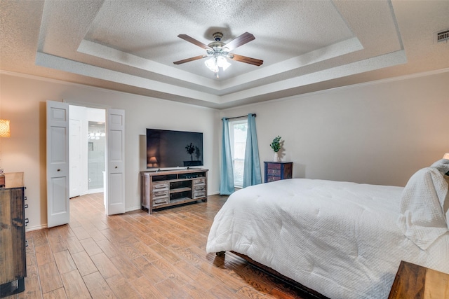 2605 Nighthawk Dr, Plano, TX 75025 - bedroom featuring a tray ceiling, light wood finished floors, a textured ceiling, and baseboards