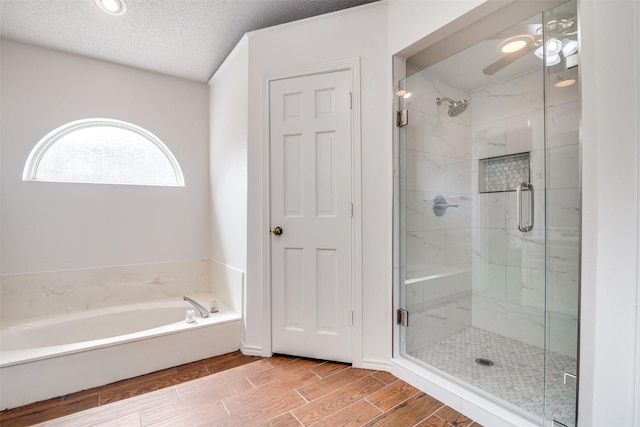 2605 Nighthawk Dr, Plano, TX 75025 - bathroom with ceiling fan, wood finish floors, a shower stall, and a bath