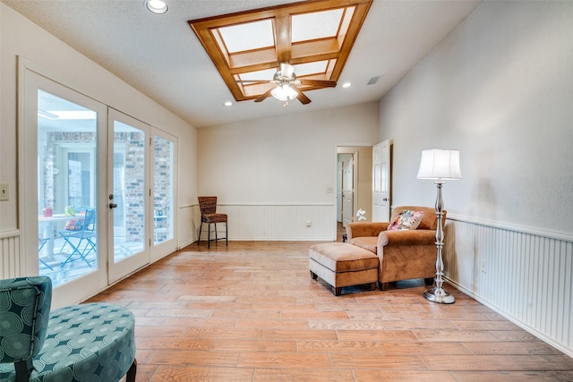 2605 Nighthawk Dr, Plano, TX 75025 - living area featuring a wainscoted wall, light wood-type flooring, a skylight, and recessed lighting