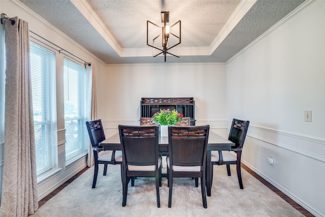 2605 Nighthawk Dr, Plano, TX 75025 - dining area with a tray ceiling, an inviting chandelier, a textured ceiling, and ornamental molding