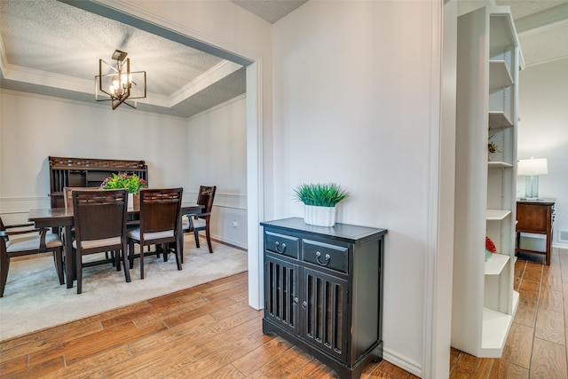2605 Nighthawk Dr, Plano, TX 75025 - dining area with crown molding, a textured ceiling, an inviting chandelier, and hardwood / wood-style flooring