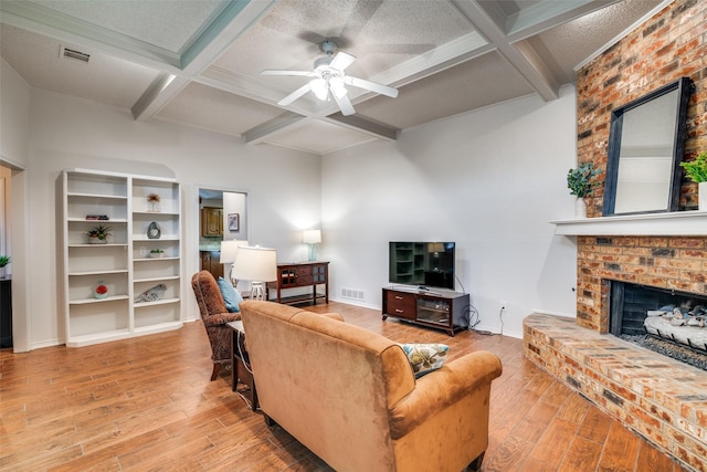 2605 Nighthawk Dr, Plano, TX 75025 - living area featuring wood finished floors, a ceiling fan, coffered ceiling, beam ceiling, and a brick fireplace