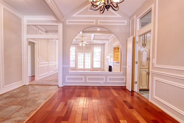 interior space with an inviting chandelier, a decorative wall, and hardwood / wood-style flooring