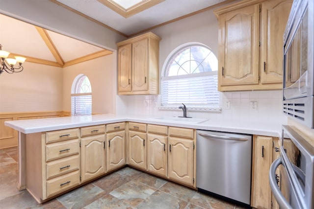 kitchen with a sink, lofted ceiling, crown molding, plenty of natural light, and stainless steel dishwasher