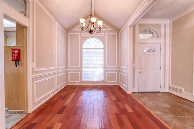 foyer entrance featuring visible vents and a decorative wall