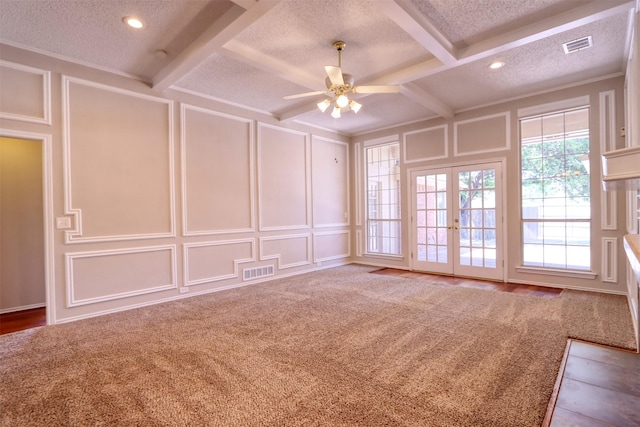 spare room with french doors, a decorative wall, visible vents, and a textured ceiling