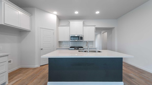 233 Pintail Ln, Rhome, TX 76078 - kitchen featuring stainless steel microwave, a sink, light wood finished floors, stove, and recessed lighting