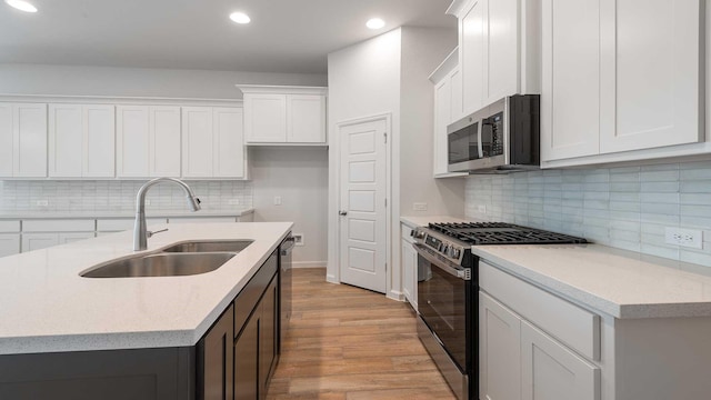 233 Pintail Ln, Rhome, TX 76078 - kitchen featuring appliances with stainless steel finishes, a sink, recessed lighting, light wood-type flooring, and tasteful backsplash