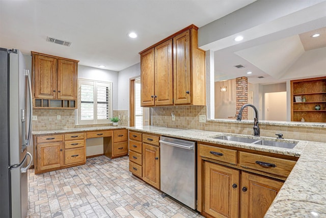 kitchen featuring stainless steel appliances, a sink, open shelves, brown cabinets, and decorative backsplash