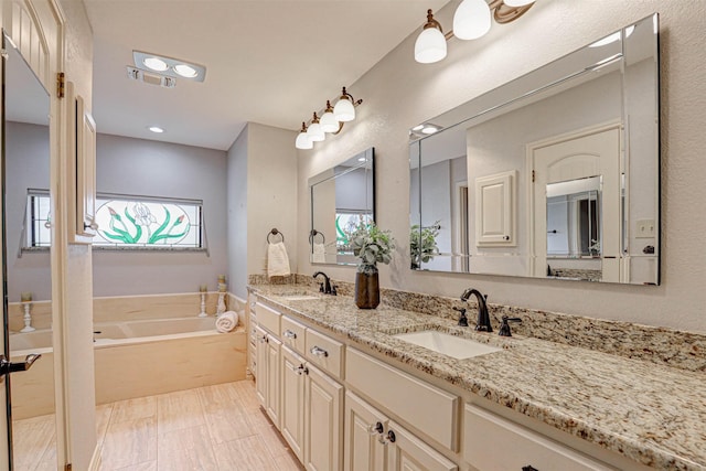 bathroom with a bath and double vanity