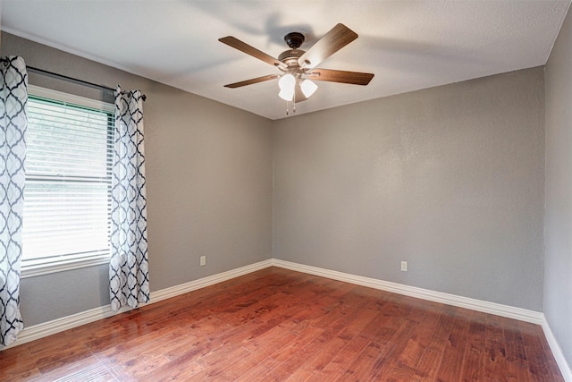 spare room featuring ceiling fan, wood finished floors, and baseboards