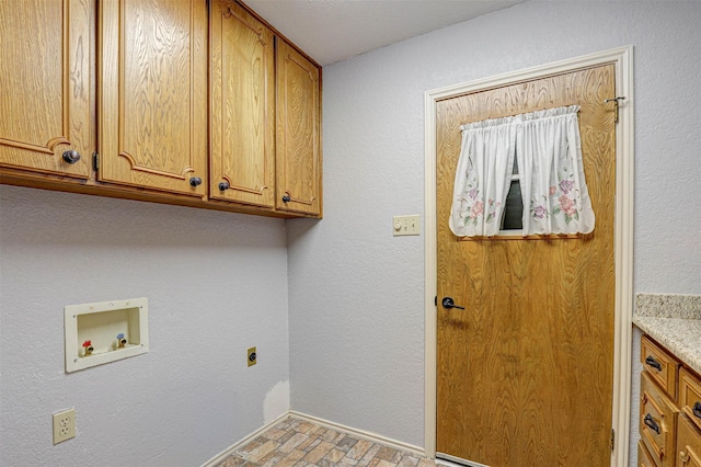 laundry area featuring cabinet space, hookup for a washing machine, brick patterned flooring, and electric dryer hookup