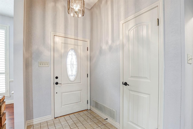 entryway with baseboards and light tile patterned flooring
